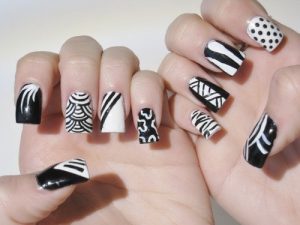 Bold, Medium, Black and White, Glossy finish, Geometric and striped accents, Trendy nail art design.