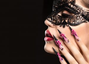 Elegant almond-shaped nails with long length, pink and black glossy finish, floral nail art, glamorous design style.