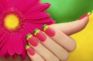 Almond-shaped nails, medium length, bright pink with yellow and green stripes, glossy finish, tropical style.