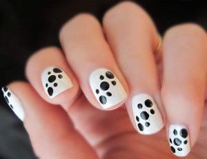 Short, squoval shape, glossy finish, white base with black spots, playful and trendy style.