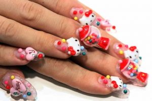 Colorful Hello Kitty-themed nail art with sprinkles.