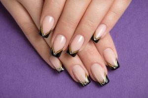 French nails with black, gold, and silver accents, short almond shape, glossy finish, minimalist geometric design, sophisticated style.