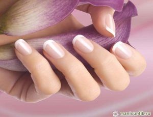 Soft oval, medium length, pale pink with white tips, glossy finish, minimal design, classic French manicure style.
