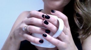 Short oval nails with black matte finish and subtle design.