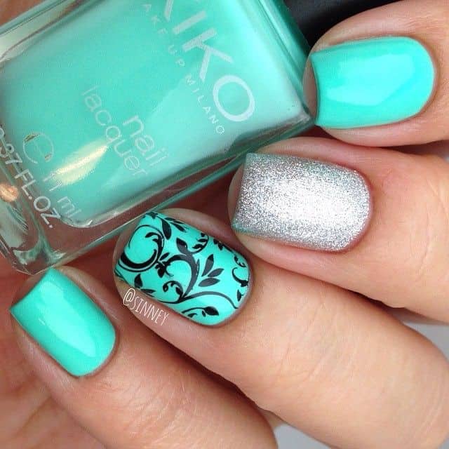 black floral design on mint green nail