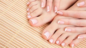 Square shape, medium length, soft pink and white palette, glossy finish, subtle French tips, classic and clean style.