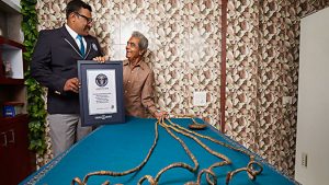 Exquisite almond nails with a long length, pink-white gradient, shiny finish, floral accents, stylish design.