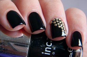Black short square nails with high-gloss finish, accent nail with gold studs.