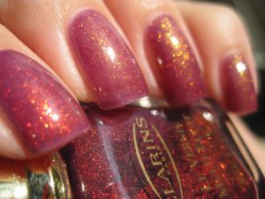 V-shaped, short, deep red with gold glitter, glossy finish, glitter accents, elegant style.