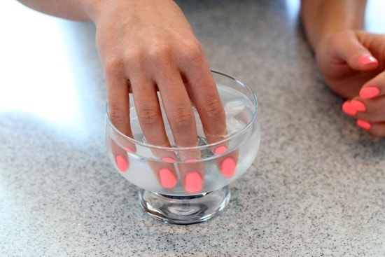 Dipping the chipped nails in ice-cold water