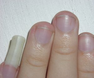 Short square nails, medium length, pastel pink and white palette, glossy finish, minimalistic design with subtle white accents, classic style.