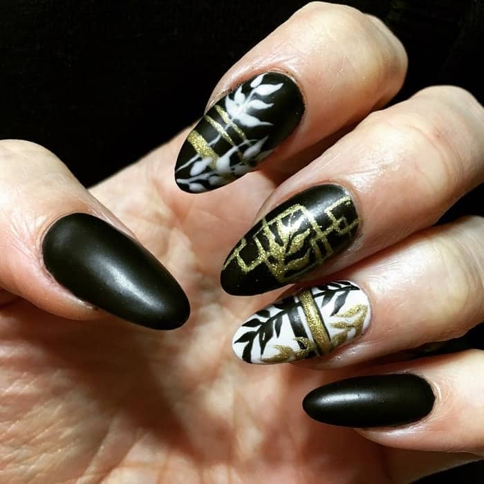 black and white nails with gold rhinestones