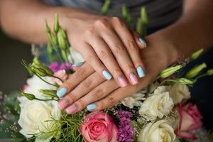 Nail shape: almond, length: medium, color palette: pastel blue and pink, finish: glossy, design elements: subtle flower details, style: feminine and soft.