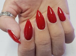 Long almond-shaped nails, glossy red finish, minimalistic style.