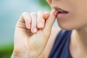 Close-up of nails with hand near lips, soft natural light, delicate and clean look.
