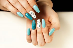 Almond-shaped, medium length with a glossy finish, pastel and glitter blue palette with floral accent art.