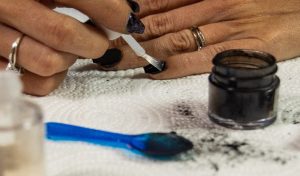 Black, nude gradient nails with glitter accents and glossy finish, oval shape, medium length.