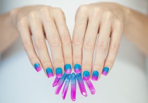Vivid almond-shaped nails with a blue to pink gradient finish.
